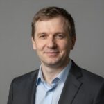 Портрет уверенного российского бизнесмена на нейтральном фоне, символизирующий надежность и профессионализм казино 1win