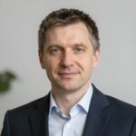 Портрет уверенного российского бизнесмена на нейтральном фоне, символизирующий надежность и профессионализм казино 1win